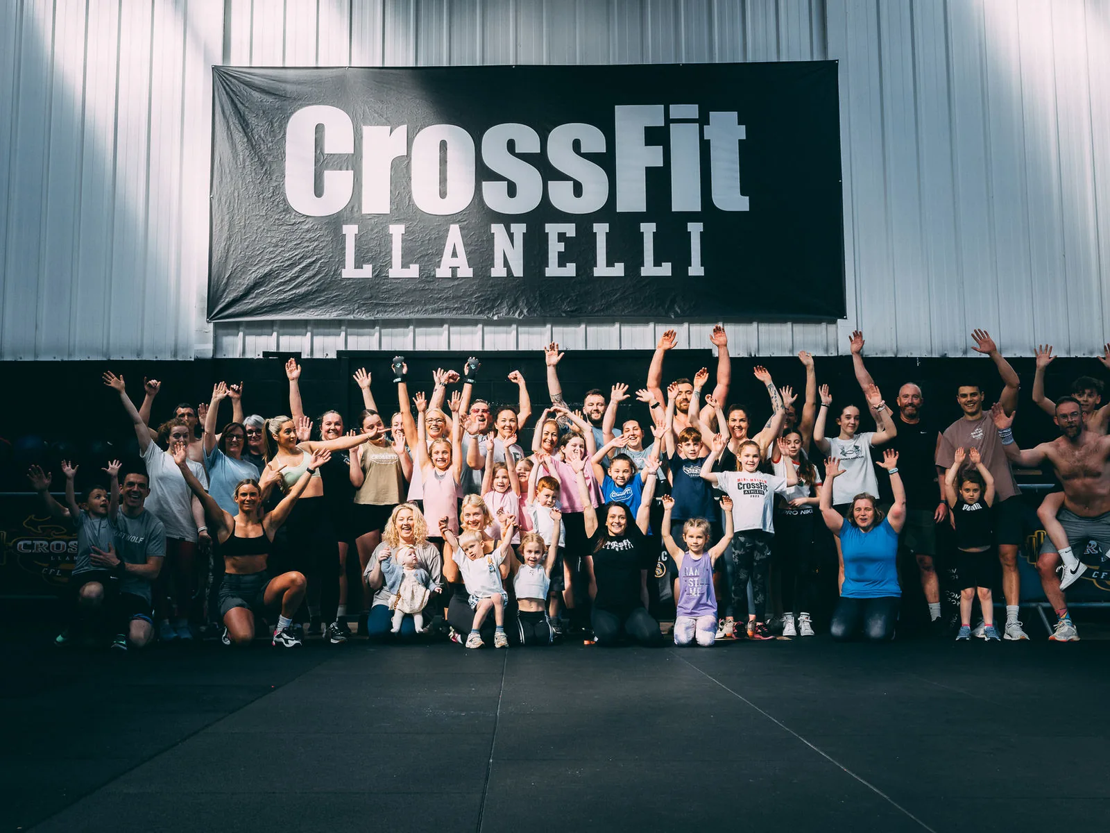 The whole CrossFit Llanelli community cheering under the gym banner